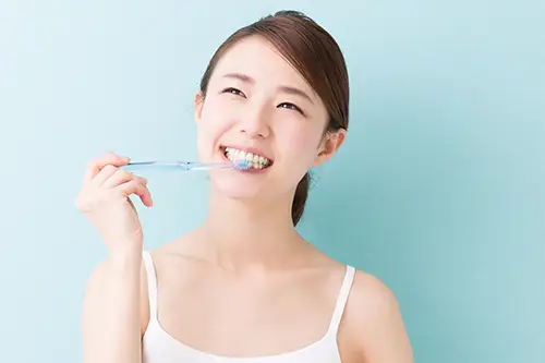 鏡で歯を見て笑顔の女性