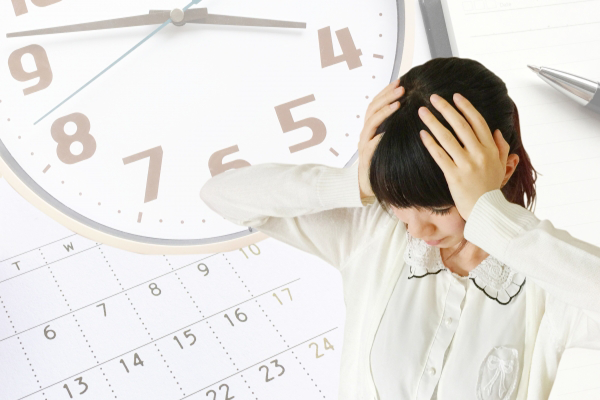時間がなく頭を抱える女性