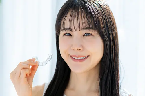 マウスピース矯正のアライナーを取り出す女性