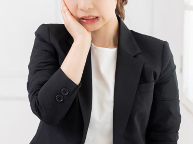 咬み合わせによる歯の痛みを感じる女性
