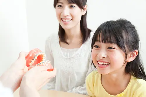 親子で歯科医師と矯正の相談をするイメージ