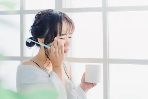 歯の痛みを感じる女性