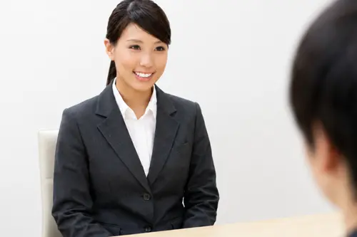 白い歯で面接を受ける女性