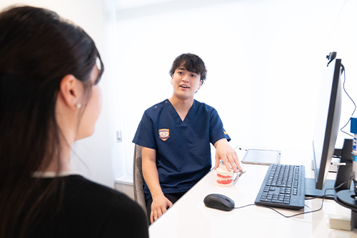 研究データを見ながら説明する歯科医師