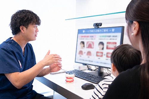 カウンセリングルームで相談する保護者と歯科医師