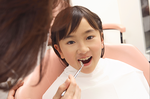 定期検診で歯の状態を確認してもらう小学生
