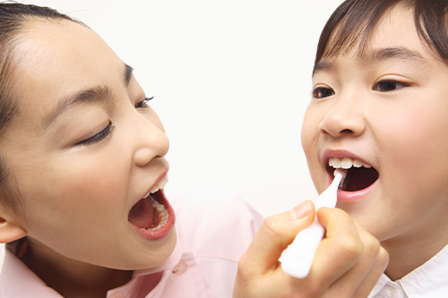歯科衛生士が子どもの奥歯の状態を確認する様子